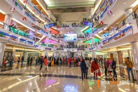 City shopping mall interior view with brand outlets and shoppers