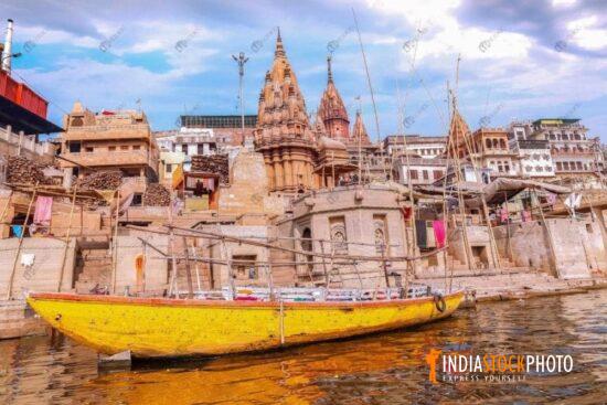 Ancient city architecture with wooden boat at Varanasi Ganges riverbank