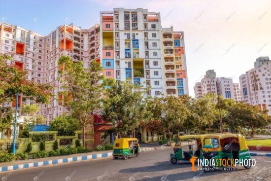 City residential building complex with auto rickshaws parked on the road
