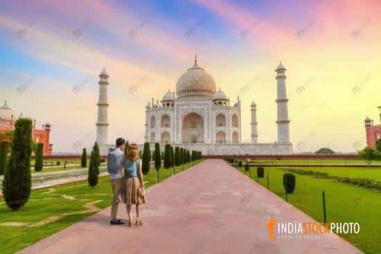 Taj Mahal Agra at sunrise with tourist couple enjoying the view