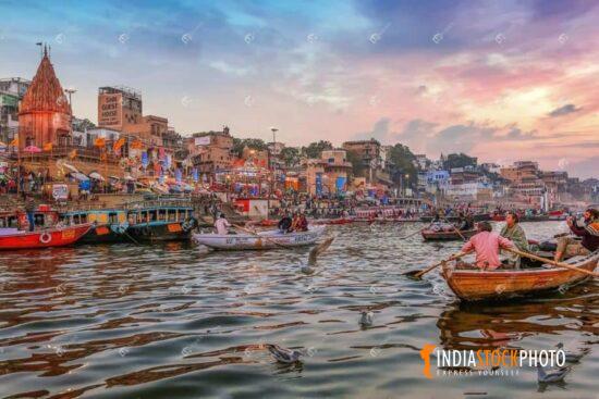 Tourist family enjoy boat ride on river Ganges at Varanasi at sunset
