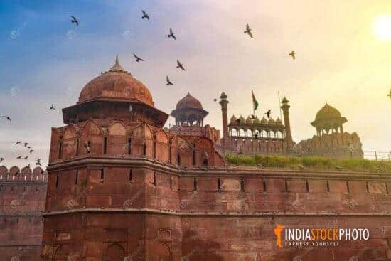 Historic Red Fort Delhi at sunrise with flying pigeons