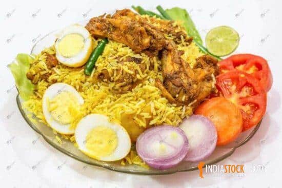 Spicy chicken biriyani with sliced eggs and salad