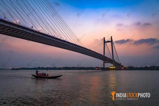Vidyasagar Setu bridge with view of a boat on river Ganges at twilight