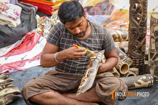 Male artist working on handicraft items for sale