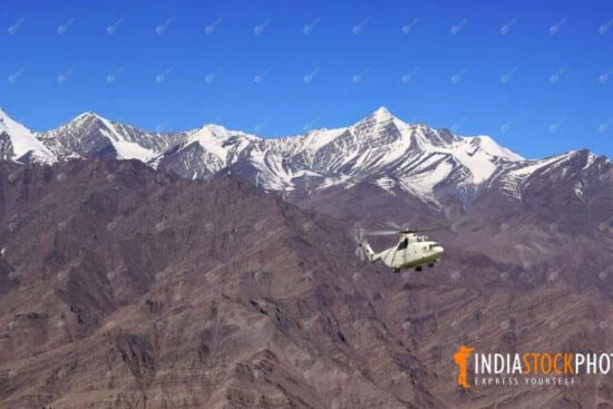 Helicopter with tourists flies over the Himalaya mountain range at Ladakh