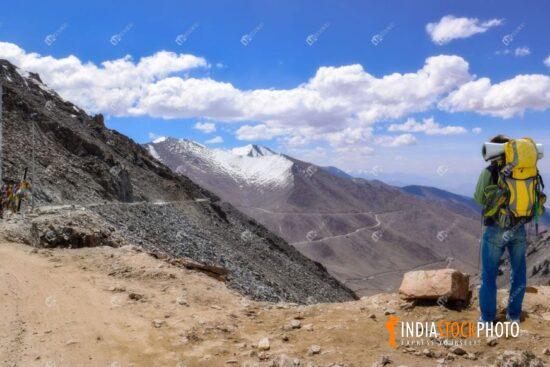 Male tourist backpacker at Ladakh Khardung la pass with Himalayan landscape
