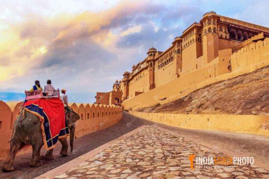 Tourist enjoy elephant ride at historic Amer Fort Jaipur at sunrise
