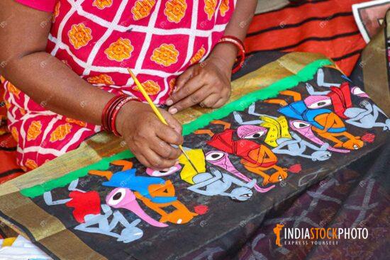 Local female artist doing fabric painting on women dress materials
