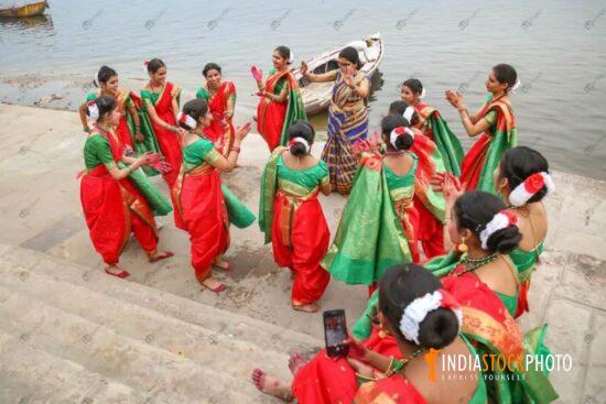 Young women in traditional dress dance and enjoy at Varanasi Ganga ghat