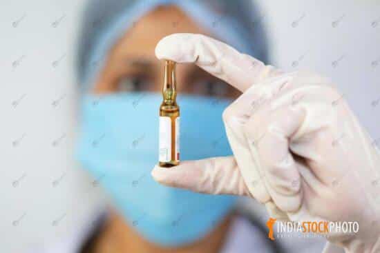 Indian doctor holds vaccine ampule in her hand
