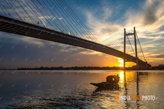 Vidyasagar Setu suspension bridge with boat on river Ganges at sunset