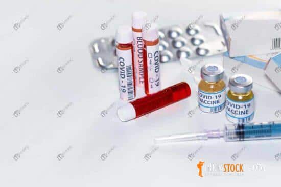 Blood vials with vaccine bottles and medicinal drugs on white background