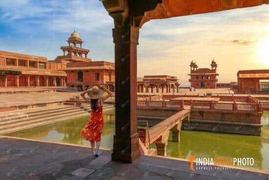 Fatehpur Sikri Agra medieval city at sunset with female tourist enjoying the view