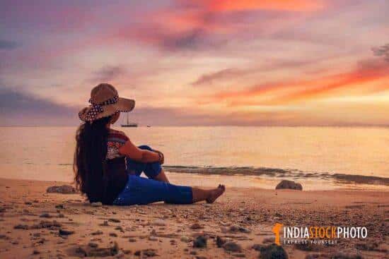 Female tourist enjoy a moody sunset at Havelock islands beach Andaman