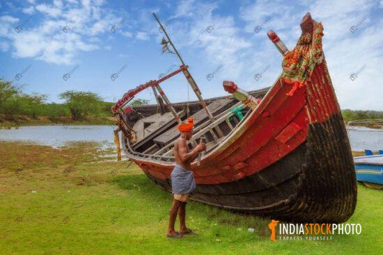 Fisherman working on his fishing boat at a rural village