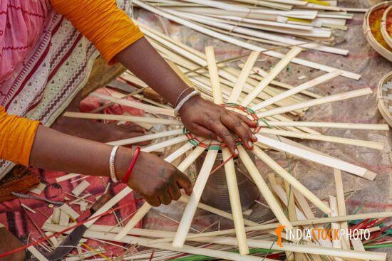 Hands of a rural woman weaving a basket with bamboo straws