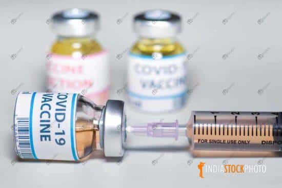 Injection syringe needle inserted in a vaccine bottle