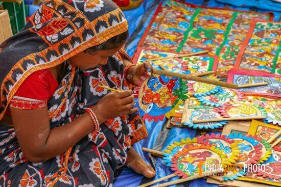 Rural Indian woman painting handicraft items for sale