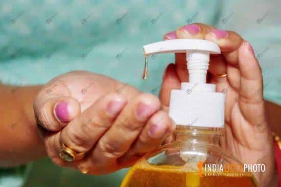 Woman hands pouring hand wash liquid to maintain hygiene