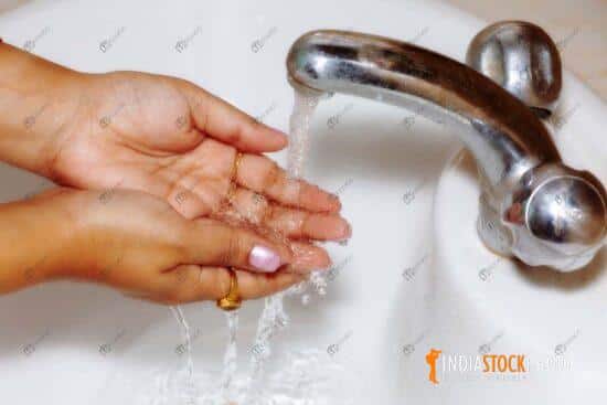 Woman washing hands as Covid 19 prevention awareness