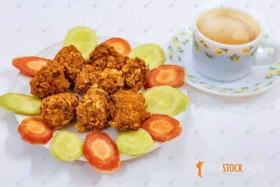 Indian snacks of crispy chicken pakora served with tea