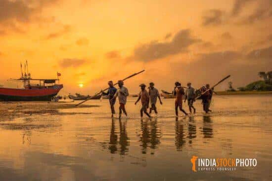 Rural fishermen return to shore at sunset near Puri Orissa