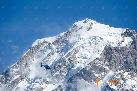 Tourist helicopter flies past Kailash Himalaya mountain range at Himachal