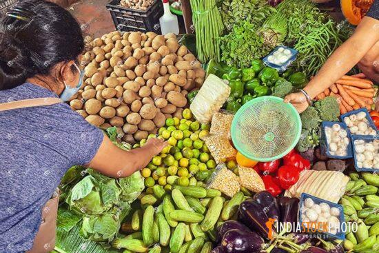 Woman customer buying vegetables from local Indian market