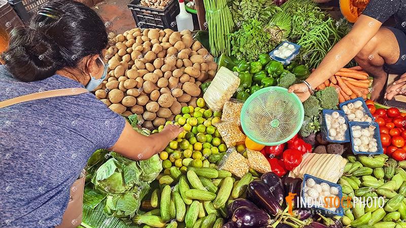 Woman customer buying vegetables from local Indian market