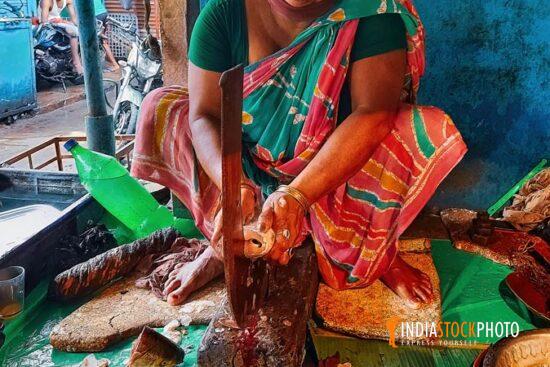 Woman slicing fish for sale at local Indian market