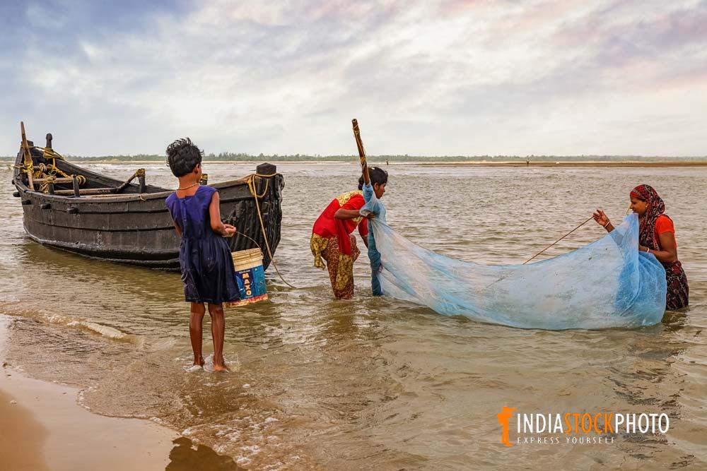 Rural women fishing with nets at coastal creek near Digha India