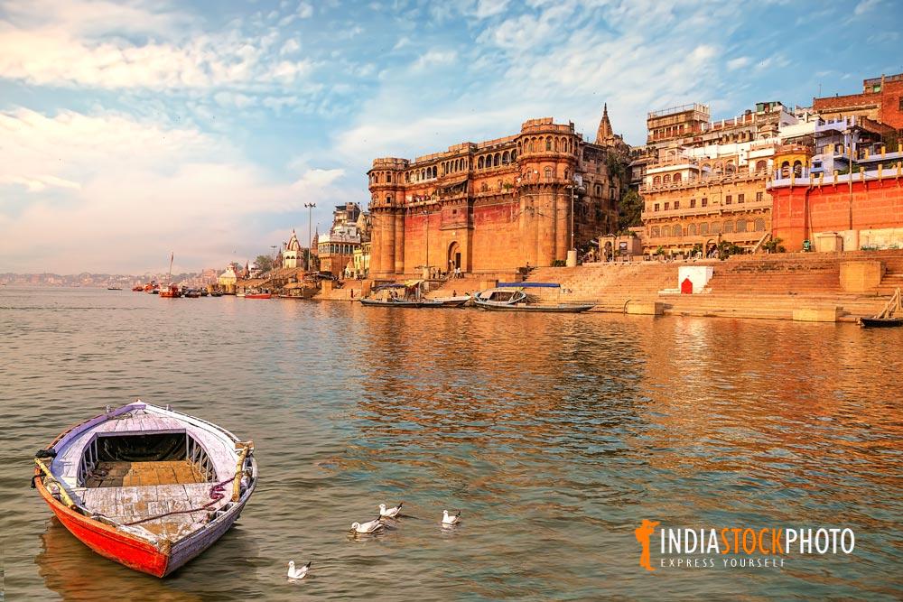 Varanasi ancient city architecture at sunset with wooden boat on river Ganges